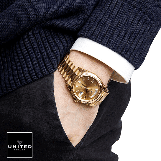 the gold Rolex Day Date watch on the man